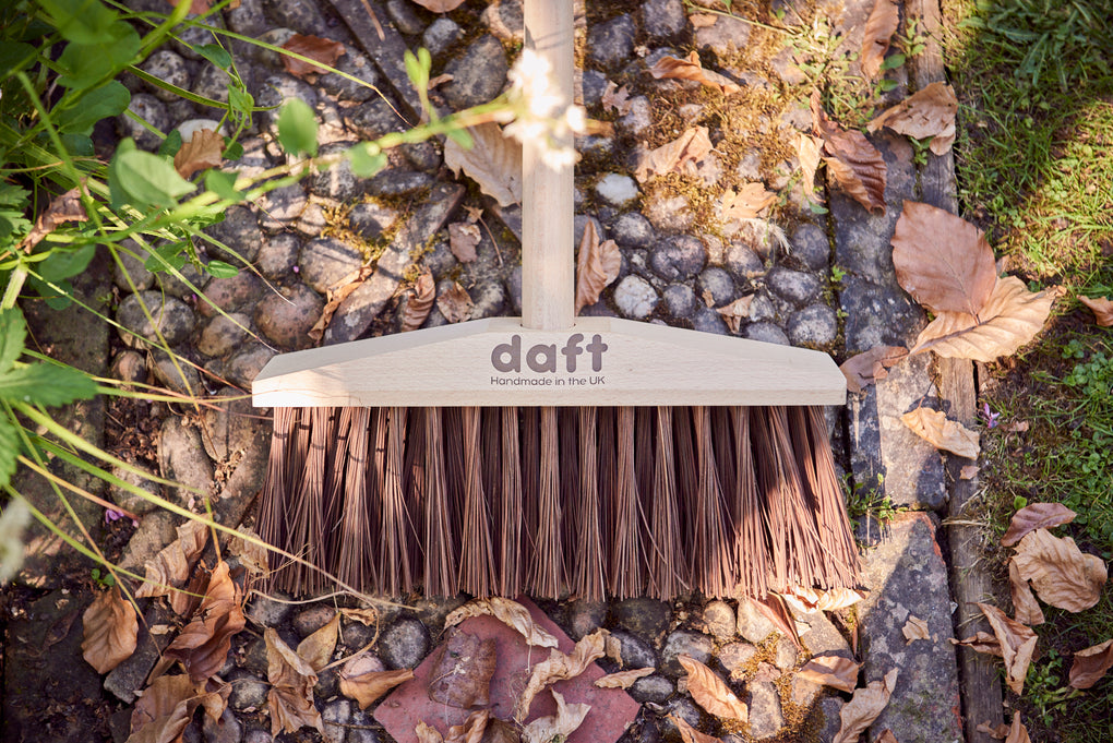 Picture of Daft broom with brown logo lying on path 